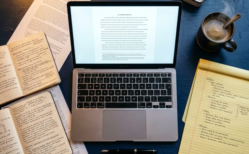 How to write 10,000 words in a weekend — laptop, outline notepad, timer and coffee on a navy academic desk